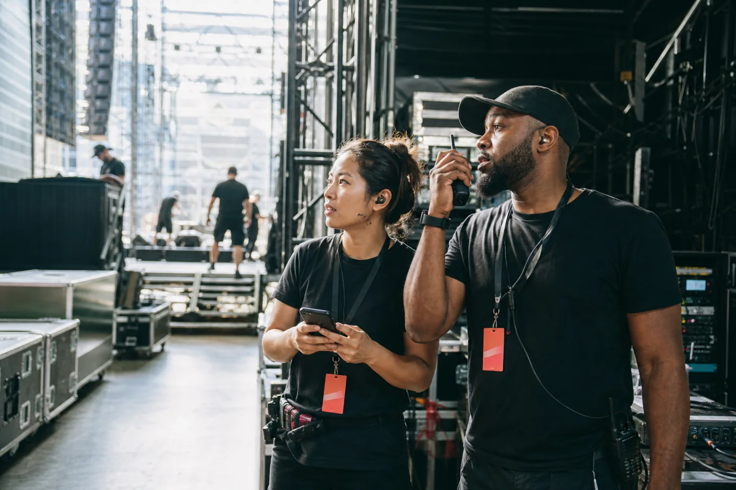 Event crew coordinating backstage using a radio and mobile phone